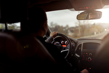 driving a car, woman driver hand on the steering wheel on a hot sunny day. vintage color.