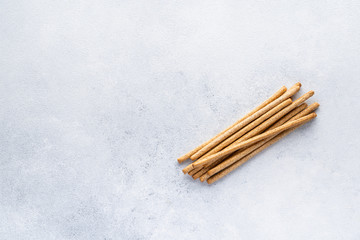 Organic Italian grissini or salted bread sticks and bread lying on a gray background. Fresh Italian snack for apero. Top view, copy space