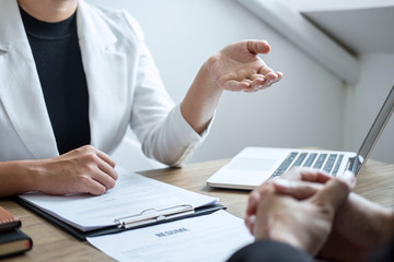 Employer or recruiter holding reading a resume with talking during about his profile of candidate, employer in suit is conducting a job interview, manager resource employment and recruitment concept