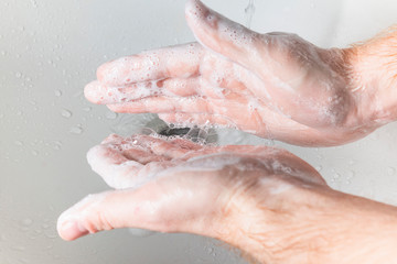 Fototapeta premium Man use soap and washing hands under the water tap. Hygiene concept hand detail.