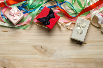 Gift box with multi-colored ribbons bow. Christmas or Valentine's Day gift boxes on wooden background. copy space