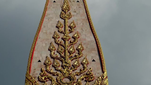 Golden coated traditional ornamental decorative elements at outer side of Thai temple at Phuket island.