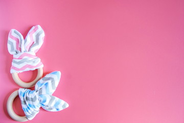 Organic cute baby bunny rabbit teether on pink background with copy space.
