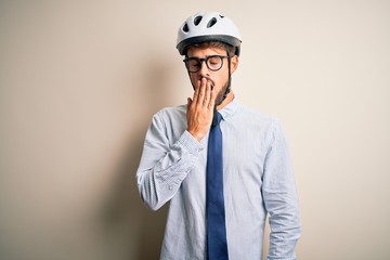 Young businessman wearing glasses and bike helmet standing over isolated white bakground bored yawning tired covering mouth with hand. Restless and sleepiness.