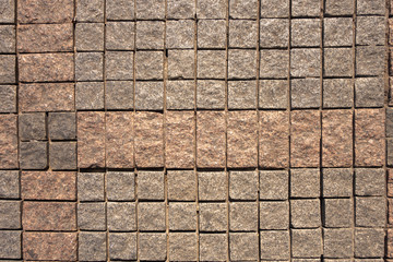 The structure of the pavers is made of granite square elements in gray and red.