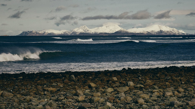 Rolling wave with snowy mountains in the distance