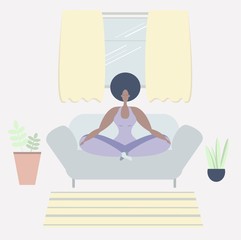 Obraz na płótnie Canvas A black woman meditates. A black woman meditates in the Lotus position on a sofa. Yoga classes at home. Maintaining psychological health. Psychological balance. The positivity of the body.