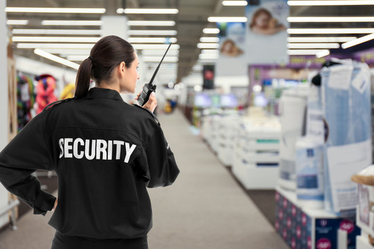 Security guard using portable radio transmitter in shopping mall, space for text