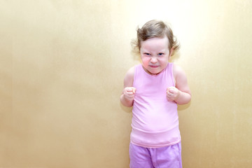 Child, girl, emotions on the face. The girl was unhappy and clenched her fists. Copy space