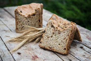 Fresh rye bread or whole grain bread on dark table background. Healthy baked bread in slices, whole homemade bread. Organic farm food. 