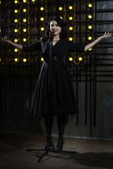 Gorgeous vintage 1950s lady with microphone in a black dress....