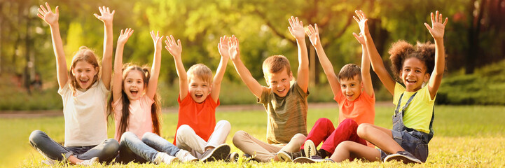 Cute little children sitting on grass outdoors on sunny day. Banner design