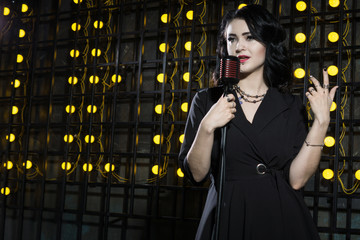 Gorgeous vintage 1950s lady with microphone in a black dress....