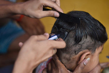 Fototapeta premium after corona virus lockdown every people in quarantine so man cut a boy hair at home with trimmer