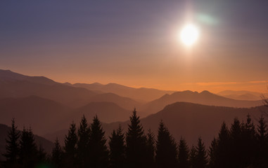 Silhouettes of mountains and trees in a sunrise with scenic view