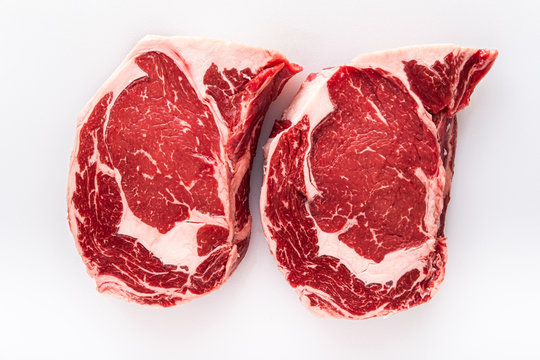 Two Freshly Cut Boneless Ribeye Steaks On A Butchers Table