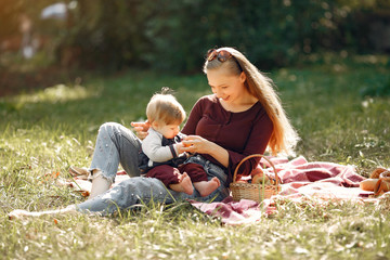 Family in a summer park. Mother in a red sweater. Cute little boy