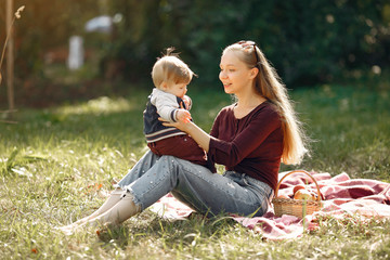 Family in a summer park. Mother in a red sweater. Cute little boy