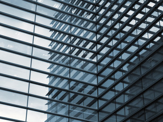 a full frame modern urban office architectural abstract with geometric shapes and buildings reflected in blue glass windows