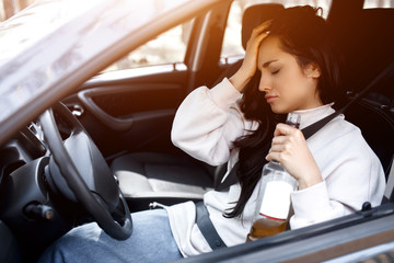 Drinking at the wheel. A drunk woman drives a car. Life threatening to drink alcohol and drive a...