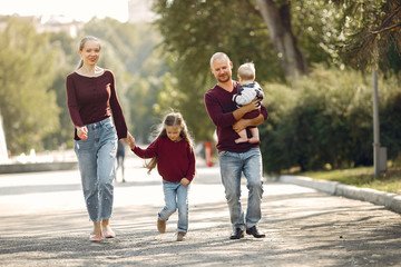 Obraz premium Family in a autumn park. Woman in a red sweater. Cute childrens with parents