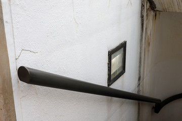 Old staircase with black metal rail and broken light