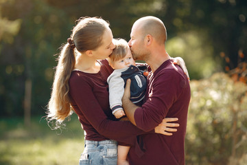 Family in a autumn park. Woman in a red sweater. Cute childrens with parents