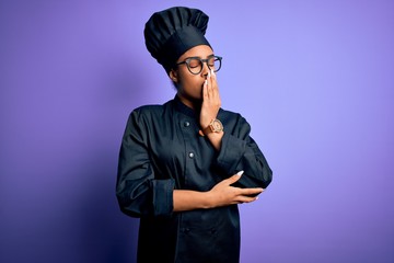 Young african american chef girl wearing cooker uniform and hat over purple background bored yawning tired covering mouth with hand. Restless and sleepiness.