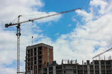Construction of an apartment building in the city: a construction crane against the sky