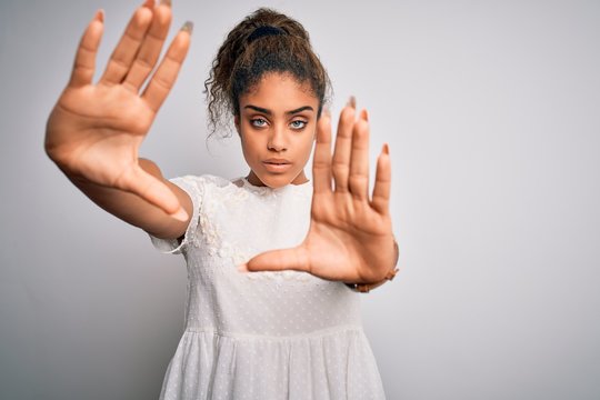 Young beautiful african american girl wearing casual t-shirt standing over white background doing frame using hands palms and fingers, camera perspective