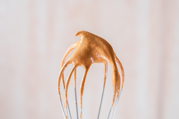 Dalgona coffee foam on a steel whisk