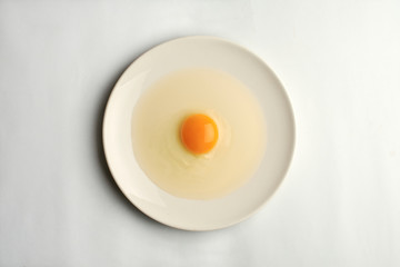 huevo crudo sobre un plato blanco