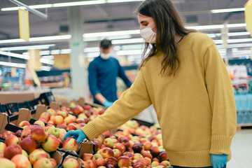 casual woman in protective gear buying fruit during the quarantine period