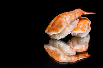 sushi on a dark background in reflection, fish, shrimp with rice