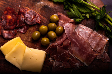 Cheese with serrano ham, olives on a table for a party with friends or as an aperitif