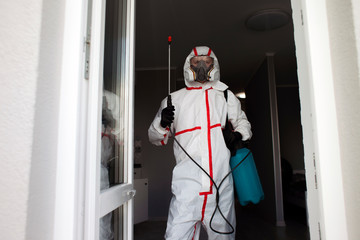 coronavirus disinfection inside the house. The disinfector in the Hazmat cleans the apartment from...