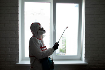 coronavirus disinfection inside the house. The disinfector in the Hazmat cleans the apartment from...
