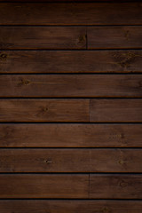 Obraz premium Medium brown wood texture backviewed from above. The wooden planks are stacked horizontally and have a worn look.