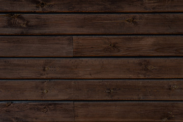 Medium brown wood texture backviewed from above. The wooden planks are stacked horizontally and have a worn look.