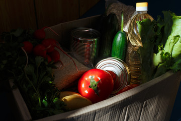 Colorful fruits and vegetables in a wooden box on a dark background. A set of products for healthy eating. Concept of eco food, detoxification of the body and weight loss.