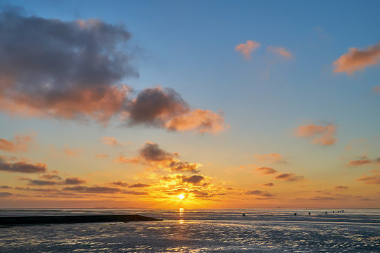 kitschy sunset at the North Sea coast in Cuxhaven-D&ouml;se (Germany)