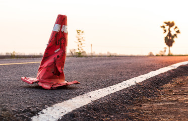The rubber cone was demolished on the paved road.