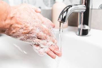  Person washing their hands with soap and hot water in the home sink wash. Cleaning the hygiene of the hand to prevent outbreaks of coronavirus. 