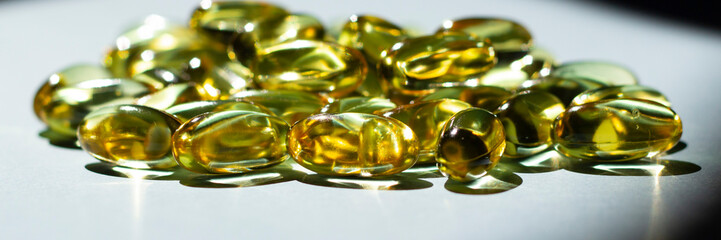 Cod liver oil omega 3 gel capsules isolated on blue background