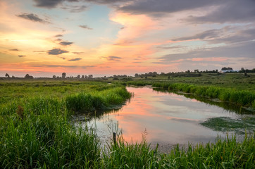 Fototapeta na wymiar Beautiful rural scenery near the lake in warm sunset light