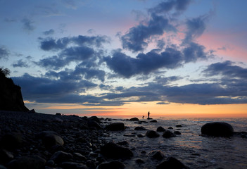 Einsame Steilküste in der Nähe von Rostock an der Ostsee mit Fähre. Typisches deutsches Reiseziel. Fischer in der Abendstimmung