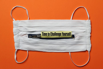 White medical mask with a zipper on an orange background. Sticker with text or caption: 