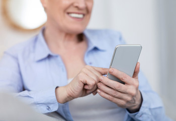 Technologies for elderly people. Modern smartphone in hands of senior woman