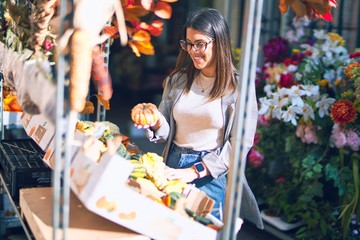 Fototapeta premium Young beautiful woman smiling happy and confident. Standing with smile on face at florist