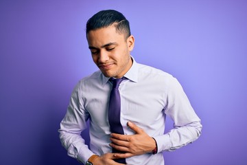 Young brazilian businessman wearing elegant tie standing over isolated purple background with hand on stomach because indigestion, painful illness feeling unwell. Ache concept.